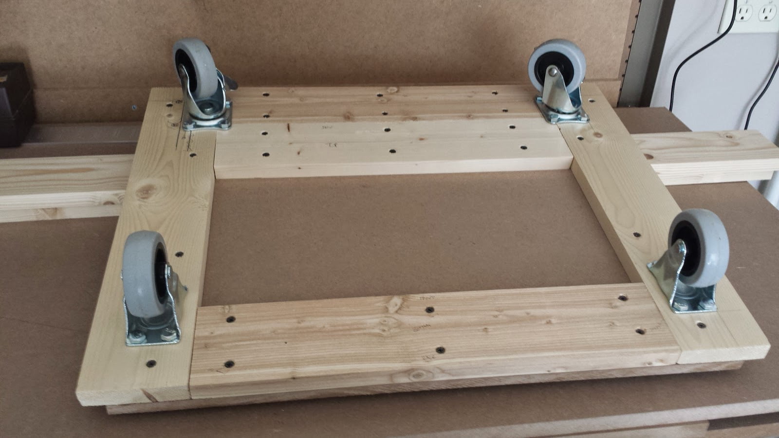 Bottom view of arcade cabinet base. Rear wheels are closest to camera.