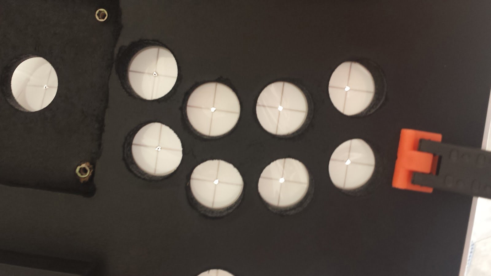 Looking up through the button holes while applying the vinyl art adhesive. Light shines through the marked button hole areas, helping to guide installation.