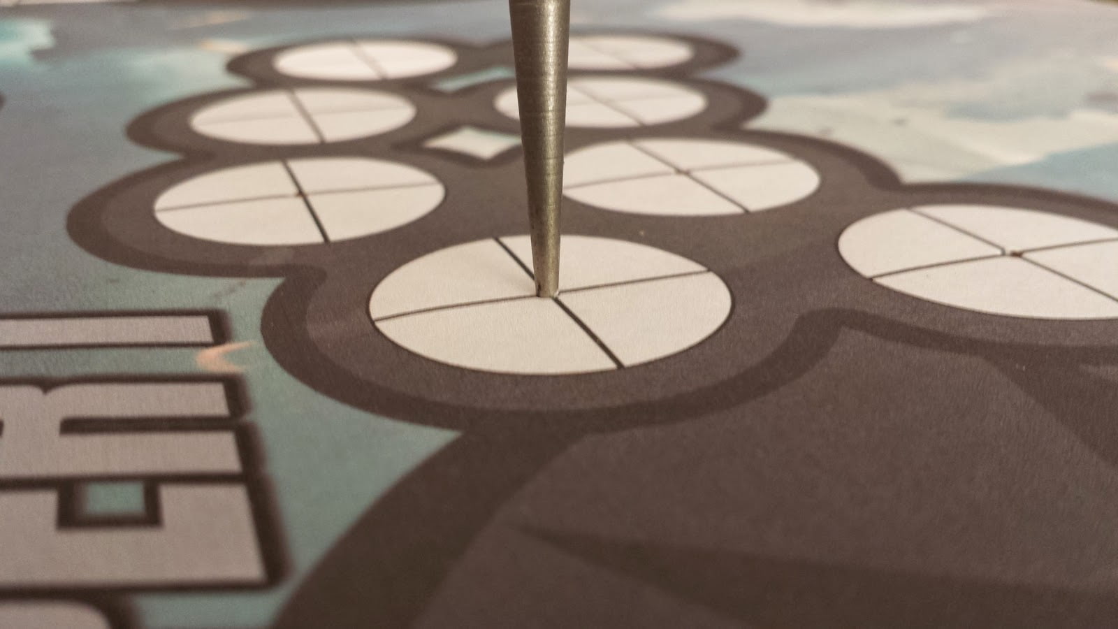 Close-up of control panel art, with crosshairs marking the center of each button location. A center punch is being used to mark the center of the button holes, through the art and into the control panel MDF.