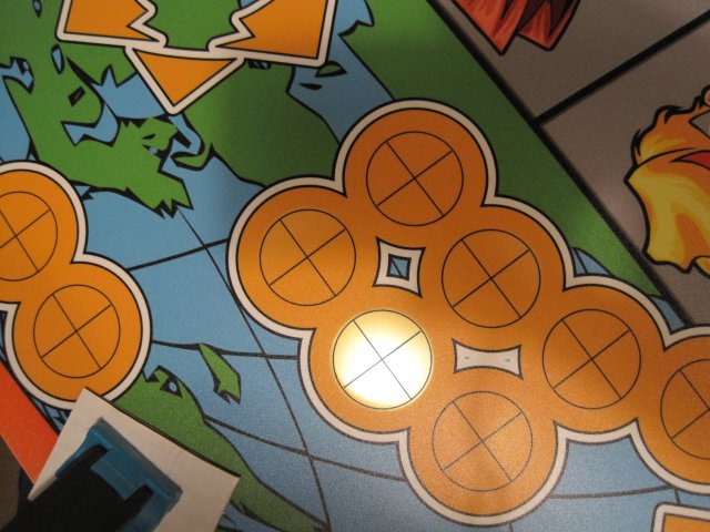 Arcade control panel artwork applied to pre-drilled MDF. A flashlight is being shined through a button hole to help guide correct placement of the art on the button holes.
